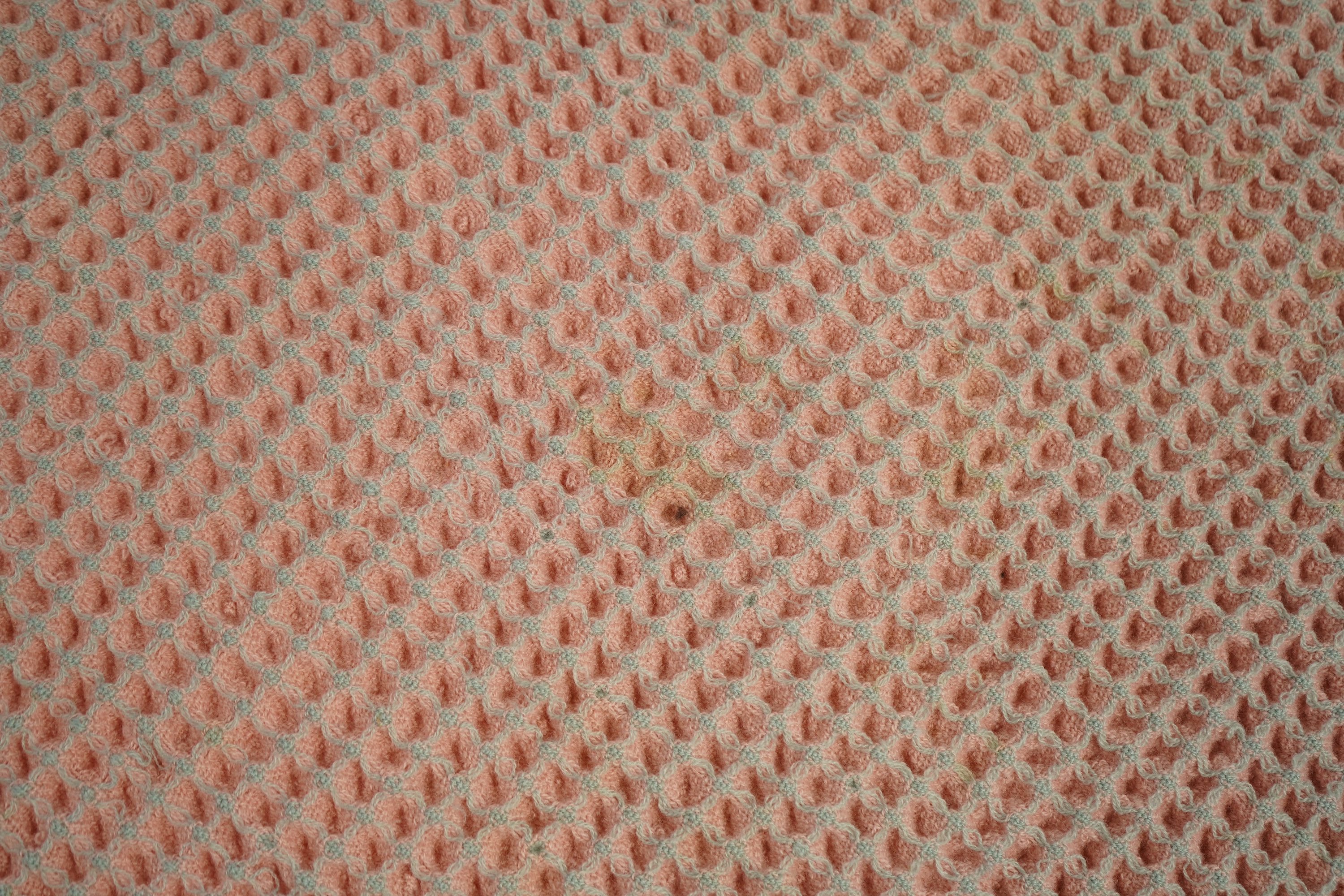 An unusual pink and grey honeycomb woven wool Welsh blanket. 194cm x 176cm. Condition - various threads have pulled and there is a small stain.